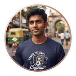 Portrait of Siddharth Rao wearing a navy blue collegiate graphic tee featuring a football badge design in an urban setting.
